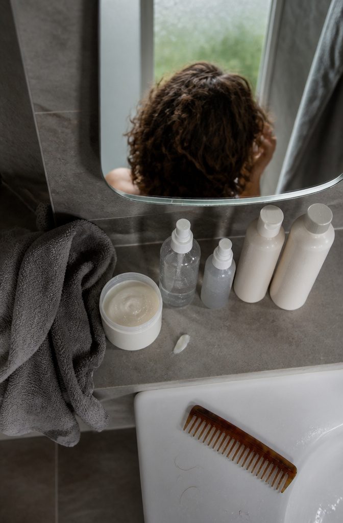 Sea salt spray and curl cream beside a man with wavy hair