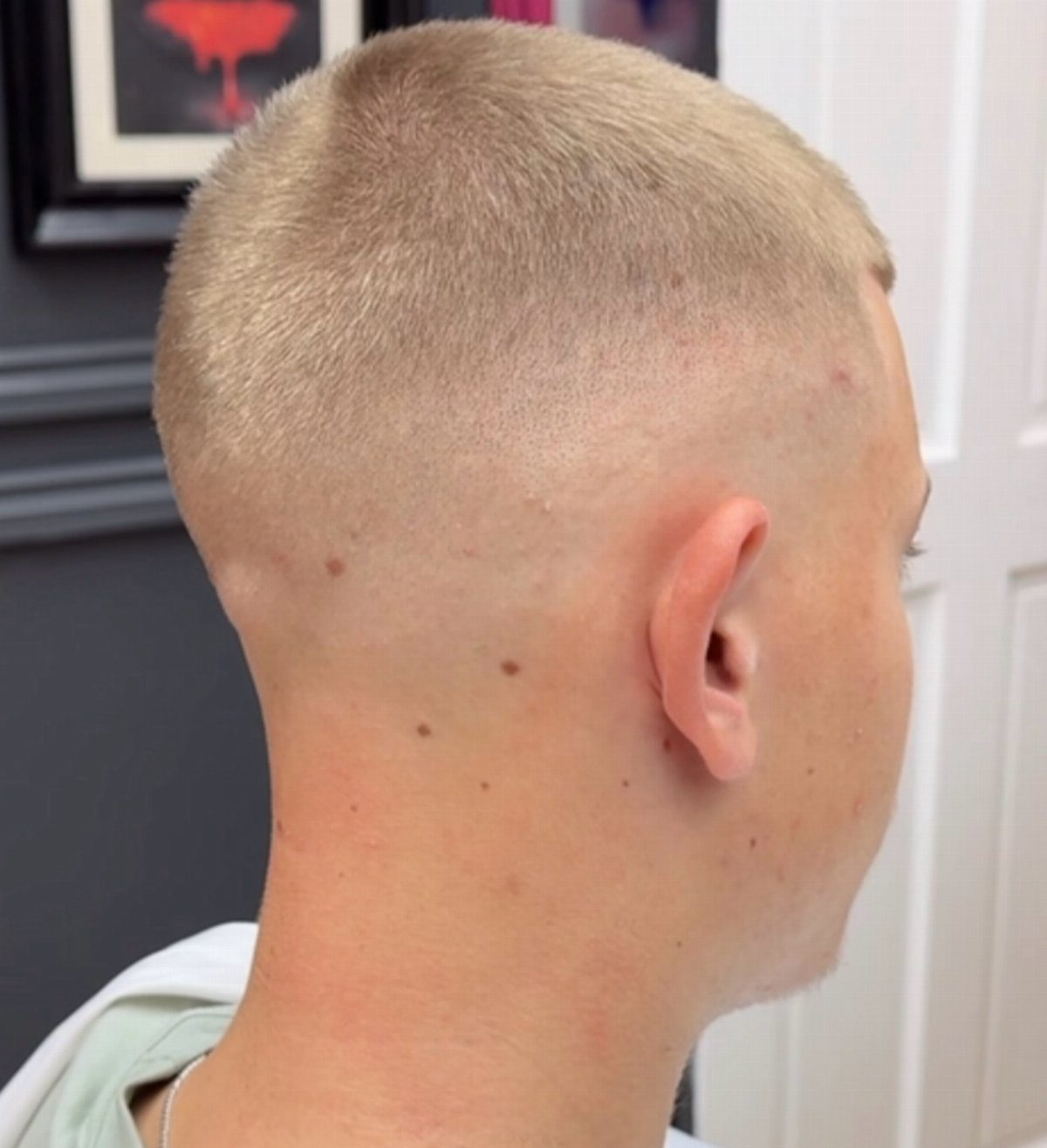 Side profile of a person with a blonde buzz cut fade haircut.