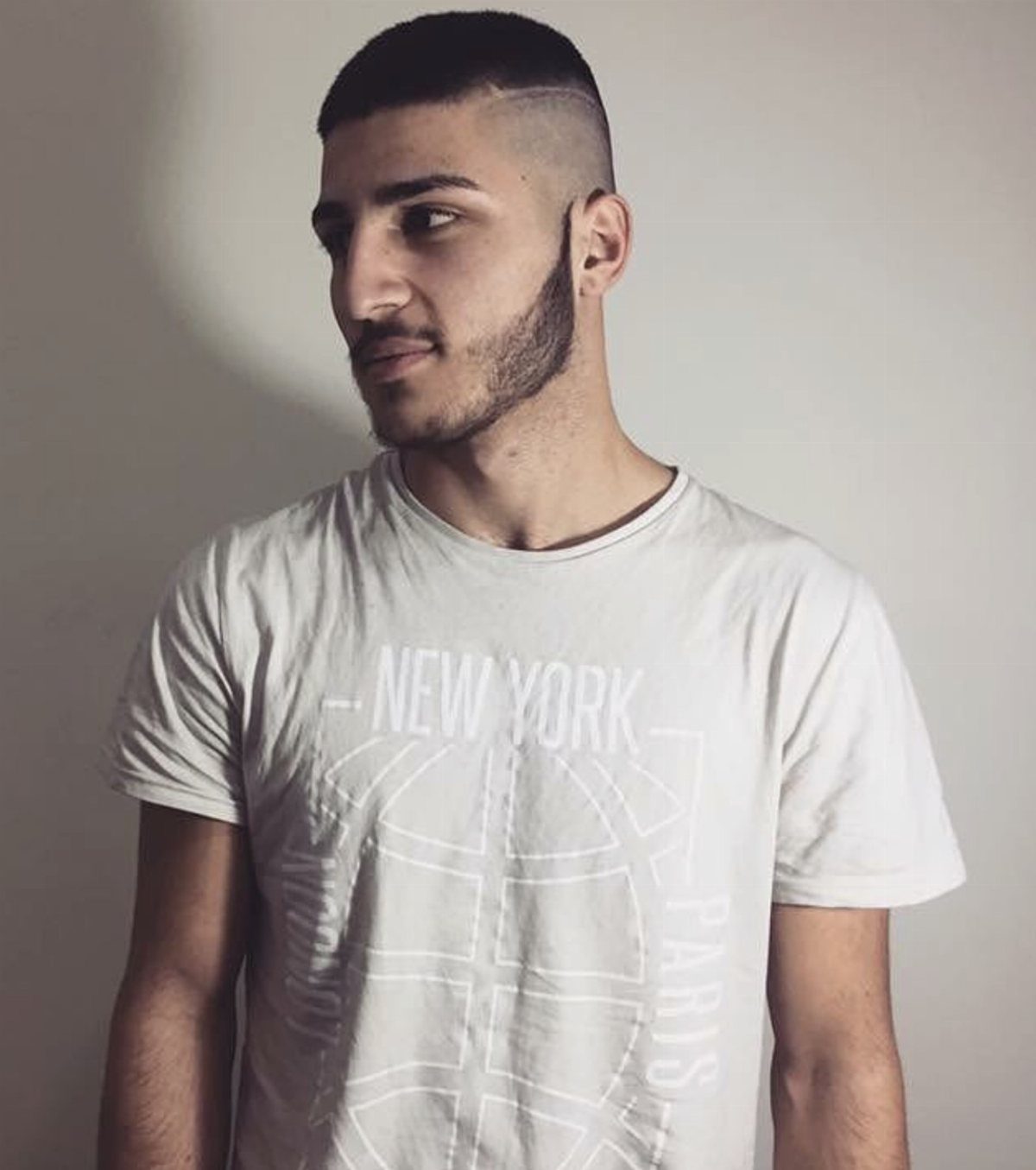 Man with a buzz cut, high skin fade, and a sharp line-up hairline.