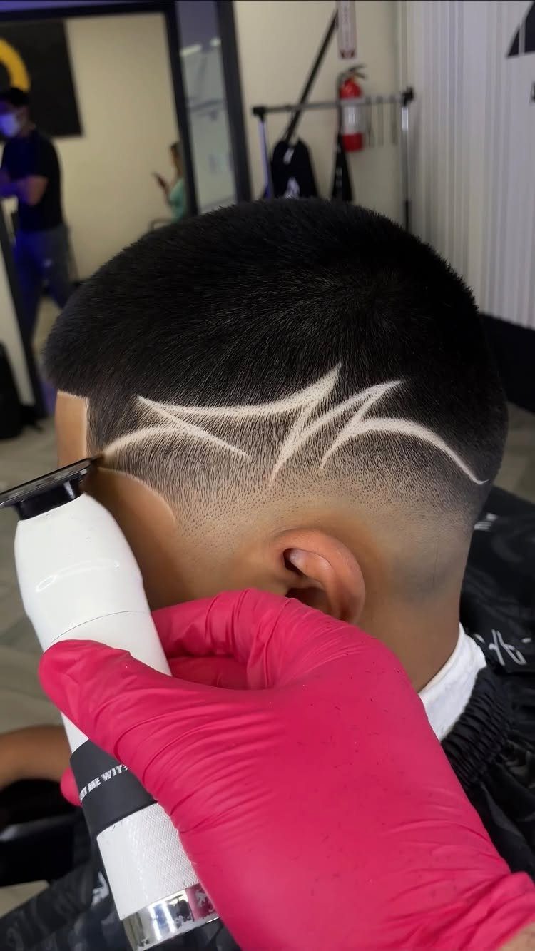 Buzz cut with a sharp zigzag shaved design on the faded side of the head.