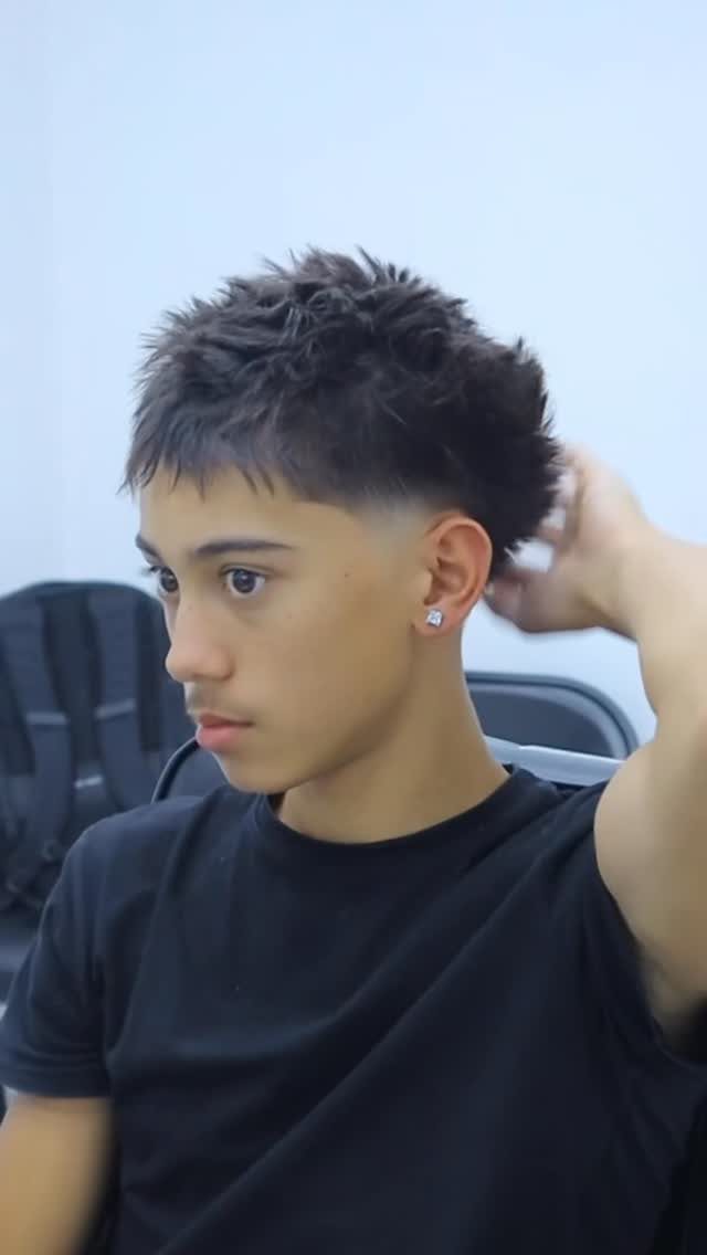 Young man with a textured buzz cut and a low fade haircut.