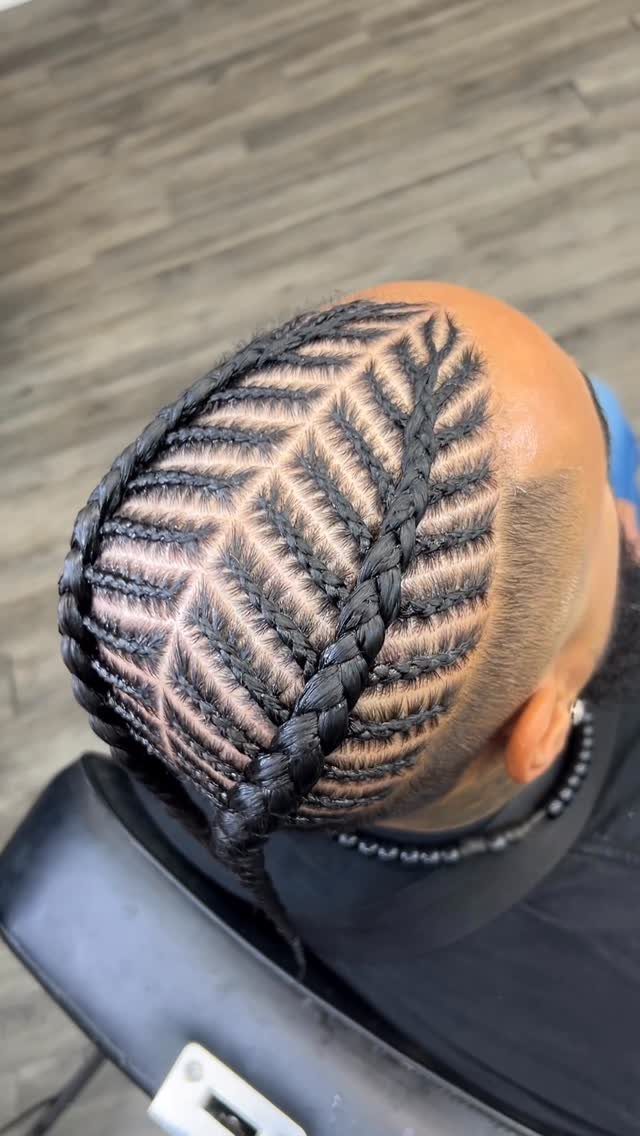 Fishbone cornrow braid pattern on a man's head with a side fade.