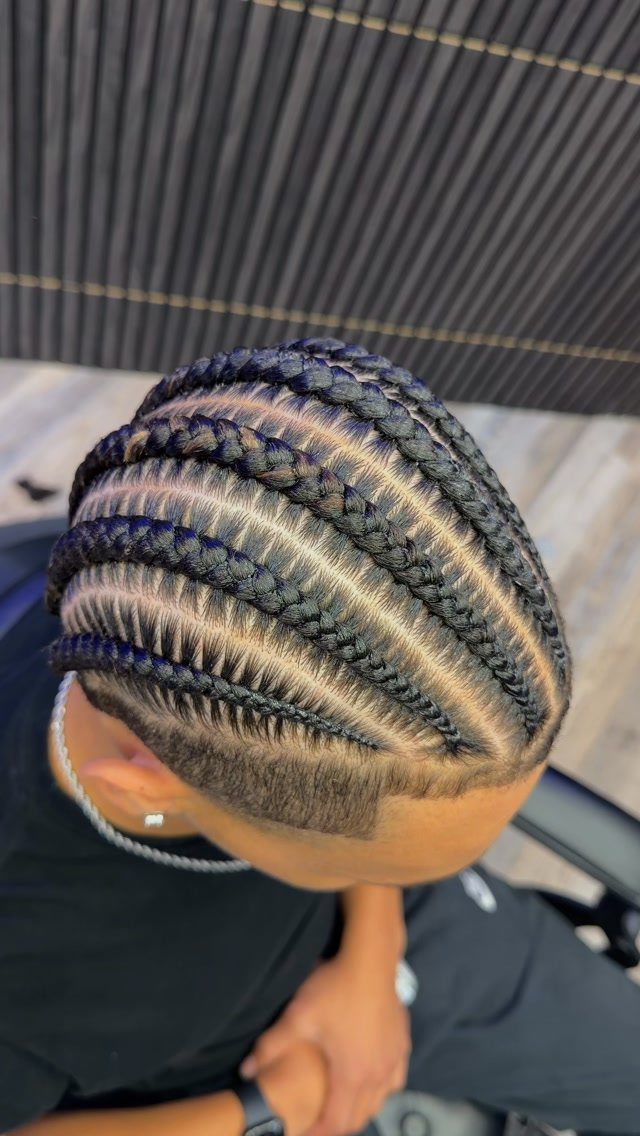Straight-back cornrows on a man with a clean fade and precise scalp parts.