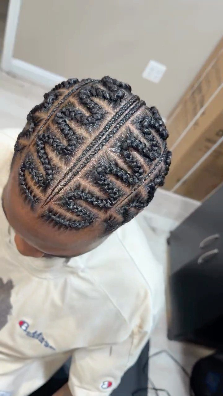 Man's head with black cornrows braided in a complex zigzag pattern across the scalp.