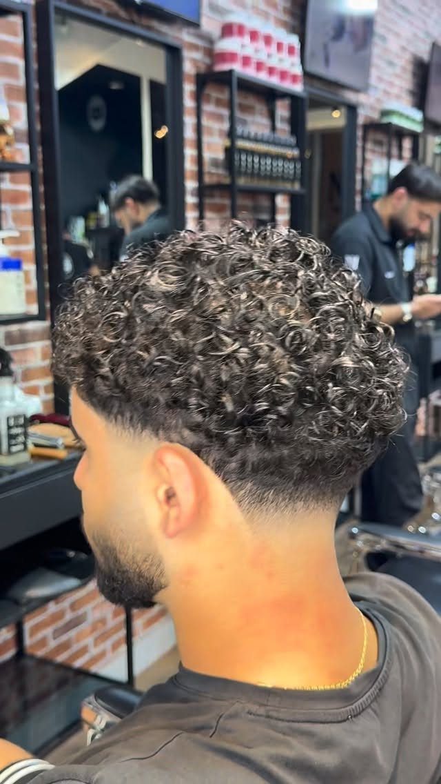 Man with a curly crop haircut and skin fade in a barbershop