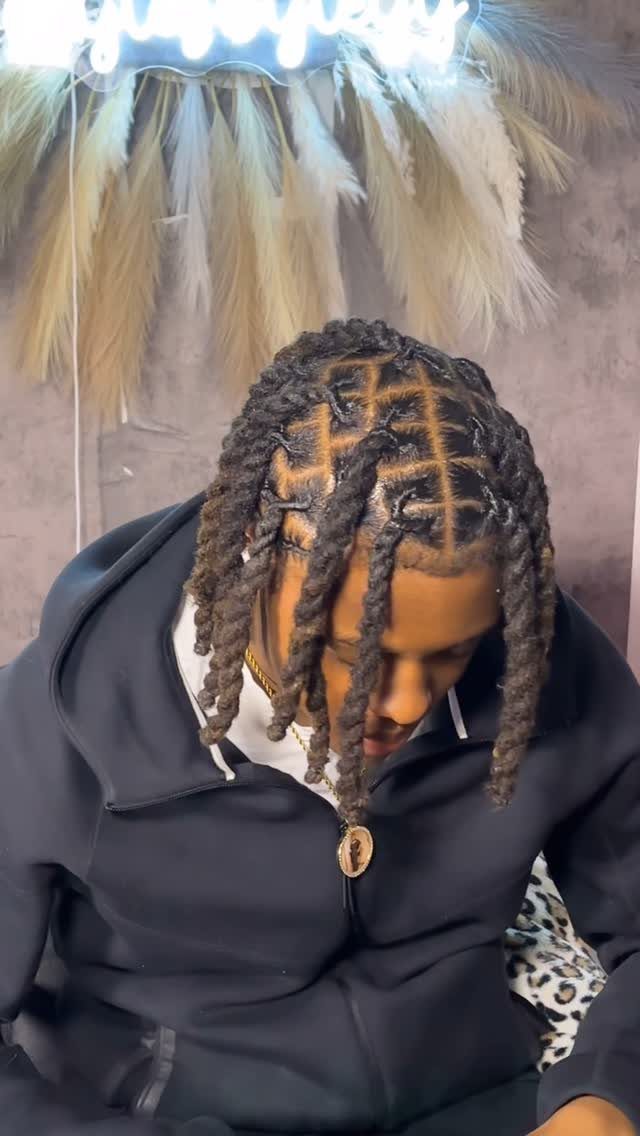Man with cornrows on top transitioning into thick twisted dreadlocks and a black hoodie