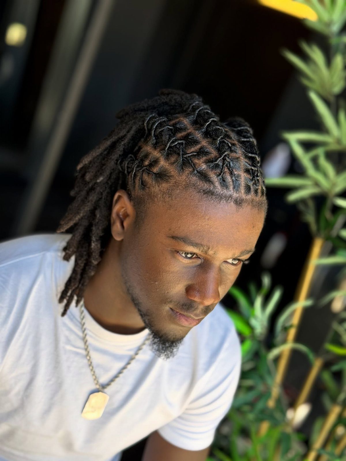 Man with long dreadlocks styled into rope twists on top of his head.
