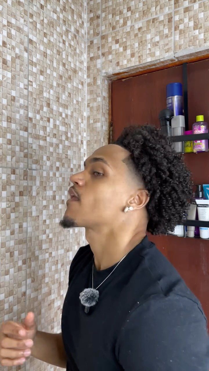 Man with curly afro hair and a clean taper fade haircut side profile