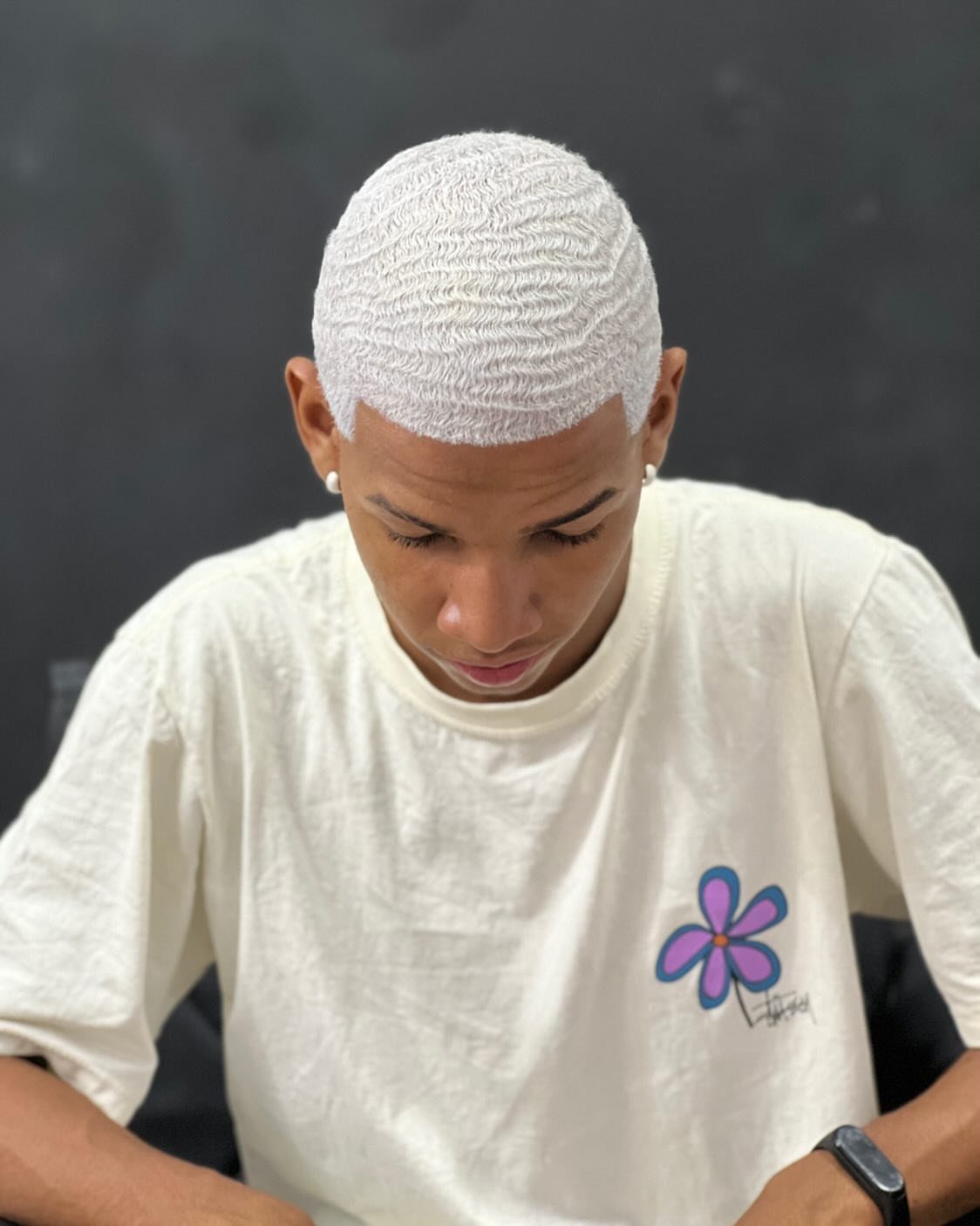Man with bleached white hair styled in deep, vintage-style finger waves.
