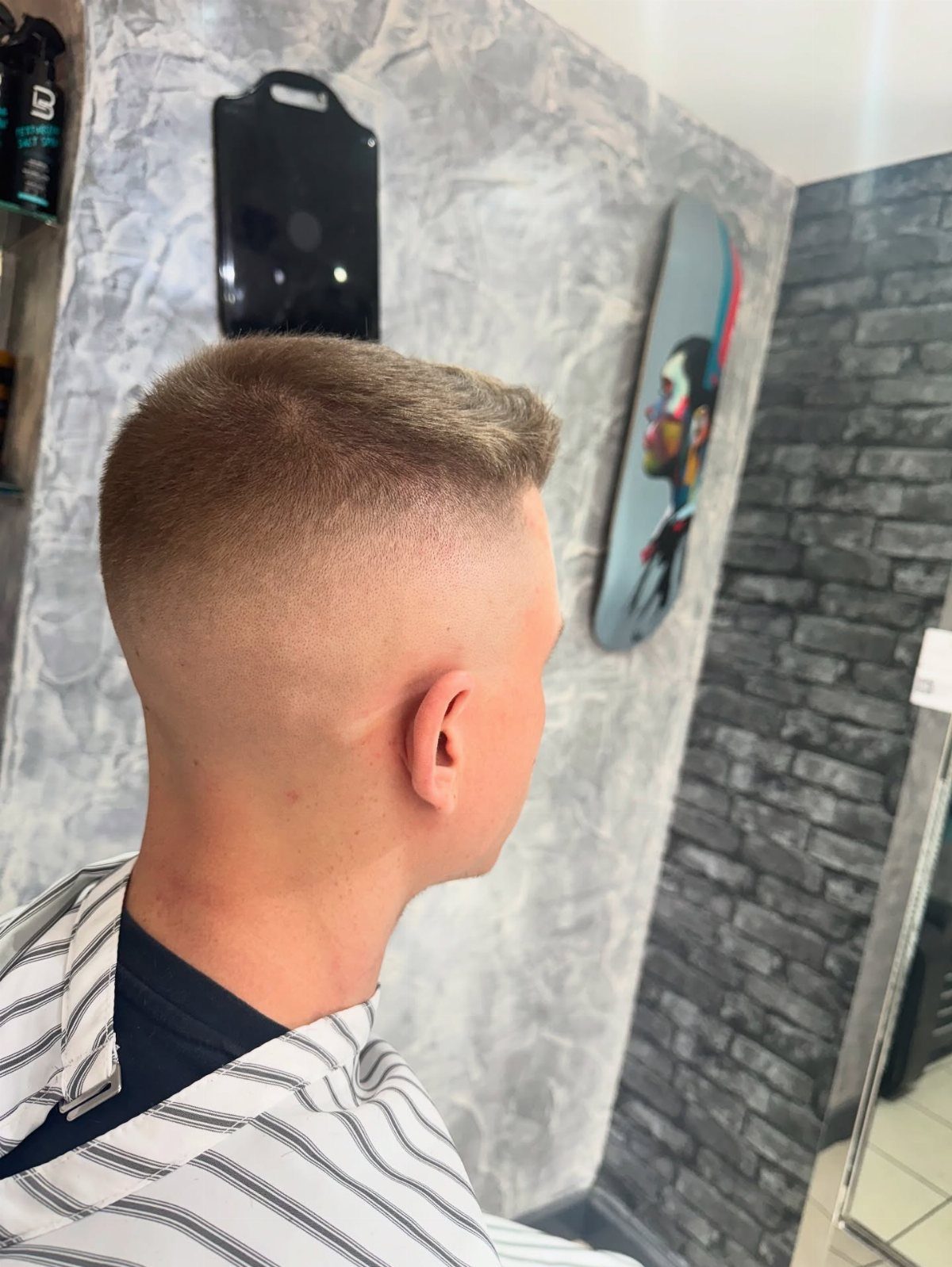 Man with a high and tight crop haircut and skin fade in a barbershop.