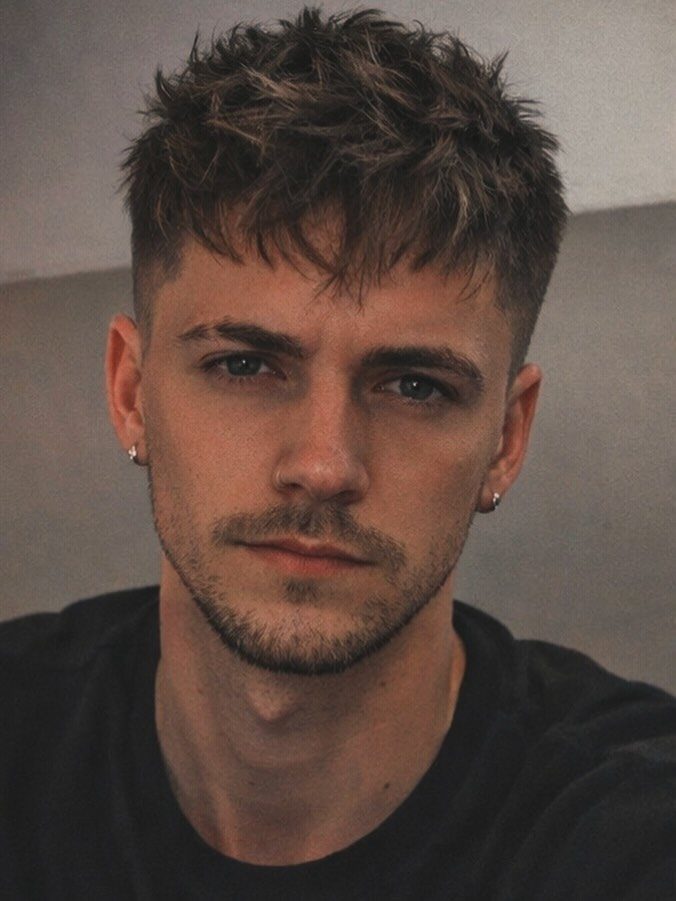 Young man with a textured crop haircut, short faded sides and messy top.
