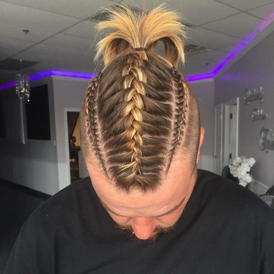 Man with blonde hair styled in intricate Viking braids and a top ponytail.