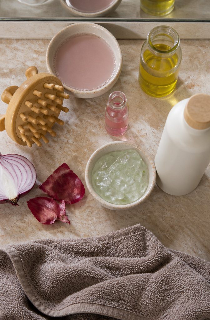 Natural scalp-care products beside a handheld scalp massager