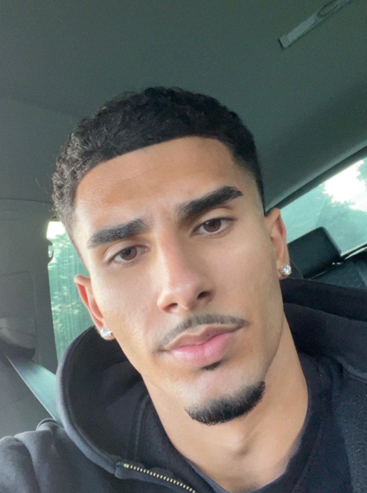 Man with short curly hair, a groomed mustache, and a chin goatee.