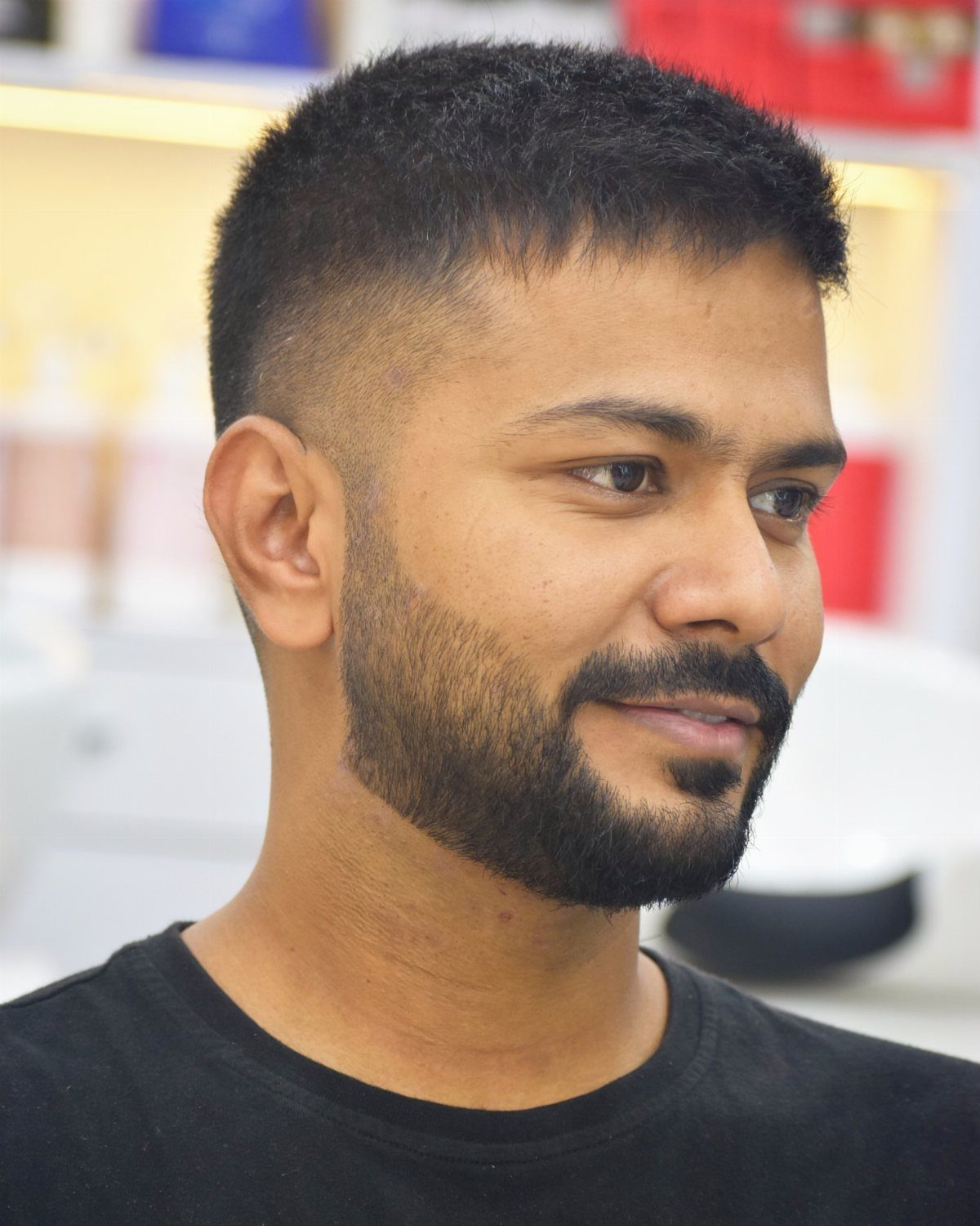 Man with short dark hair on top and a groomed full beard