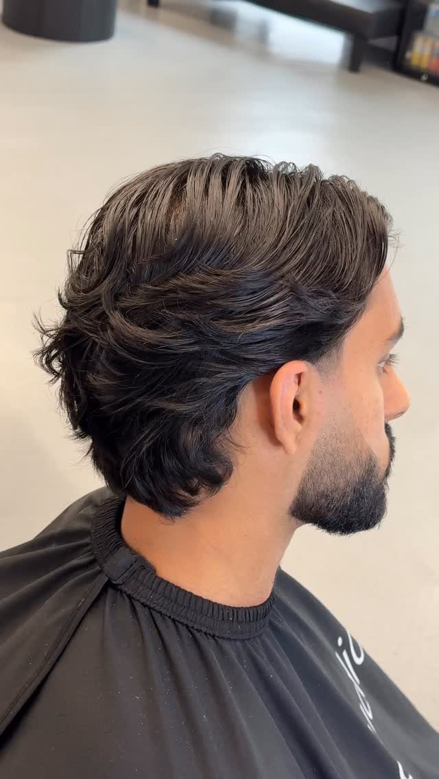 Man with medium-length dark hair brushed back in a relaxed bro flow style.
