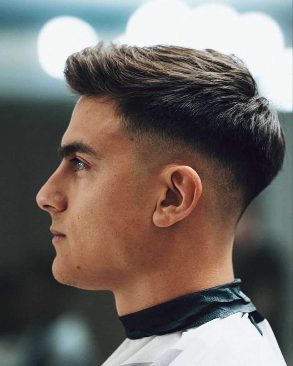 Young man with a short back and sides haircut and a tapered fade.