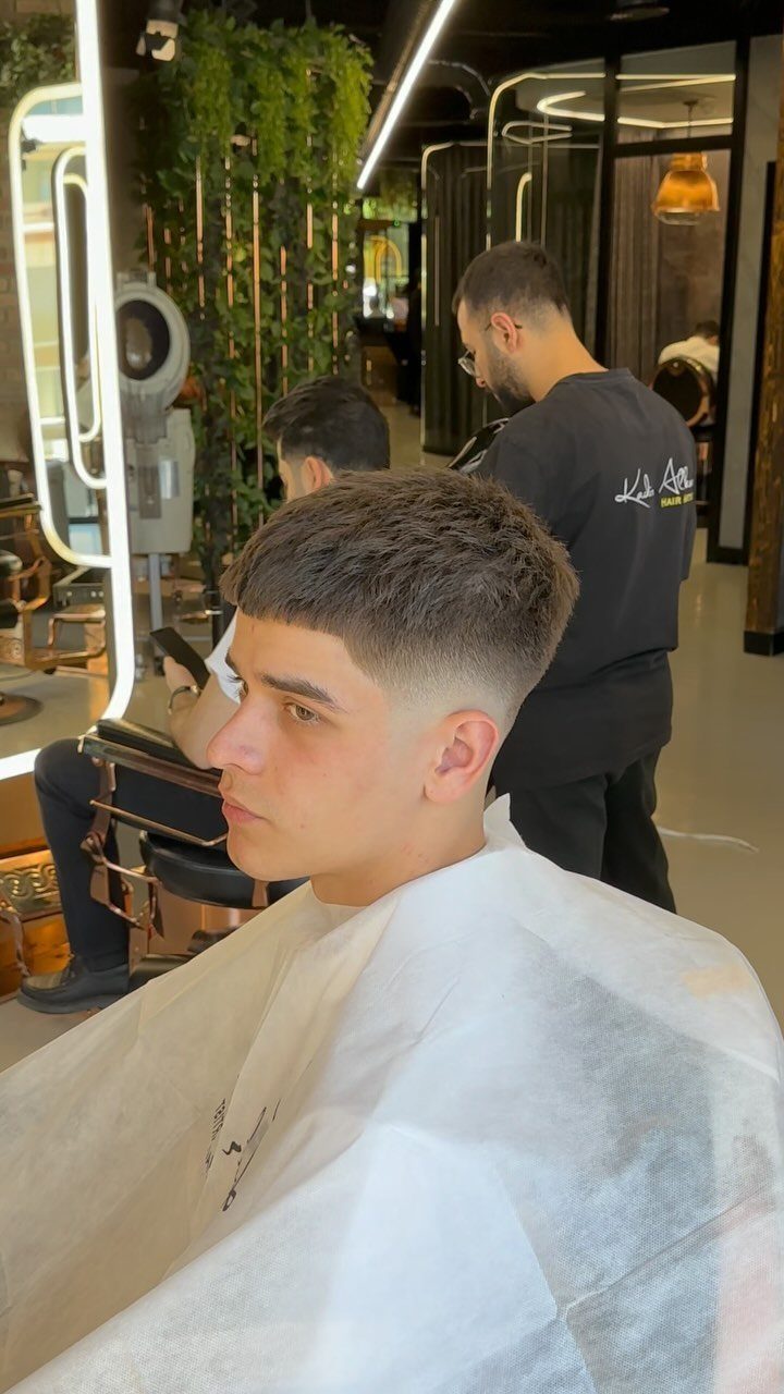 Young man with a textured crop haircut and skin fade in a barbershop.