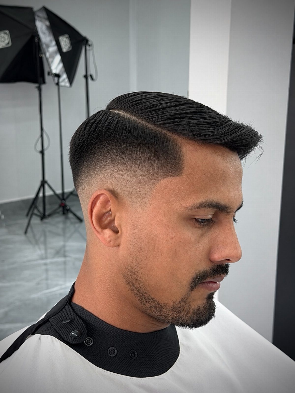 Man with a high skin fade and a sharp shaved hard part line.