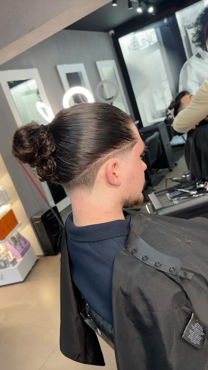 Man with a high fade haircut and a man bun in a barbershop