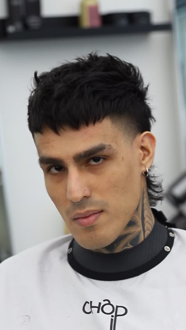 Man with a high fade mullet and textured black hair on top.