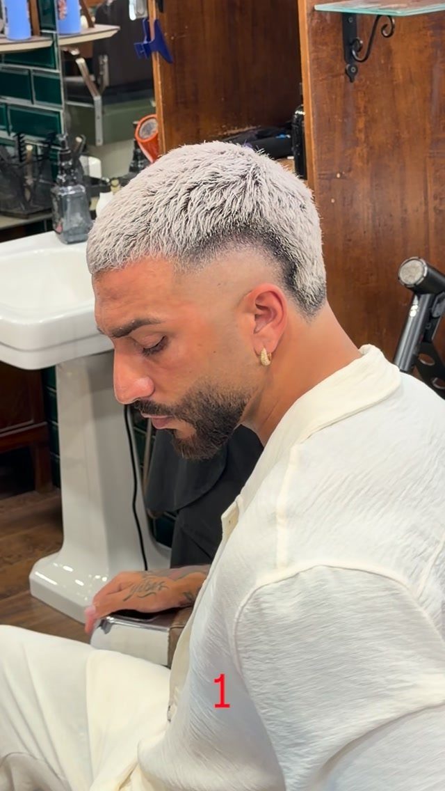 Man with bleached blonde high fade haircut and short spiked hair on top.
