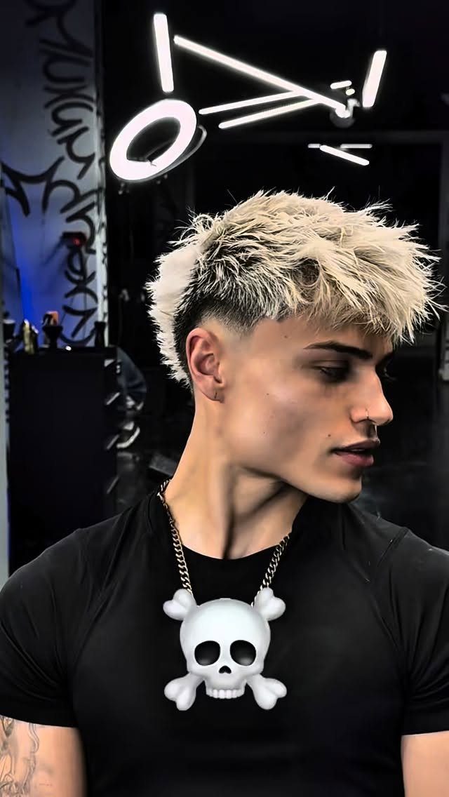 Young man with bleached blonde hair and a high taper fade haircut.