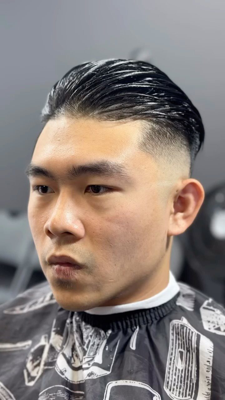 Man with slicked back hair and a high taper fade haircut