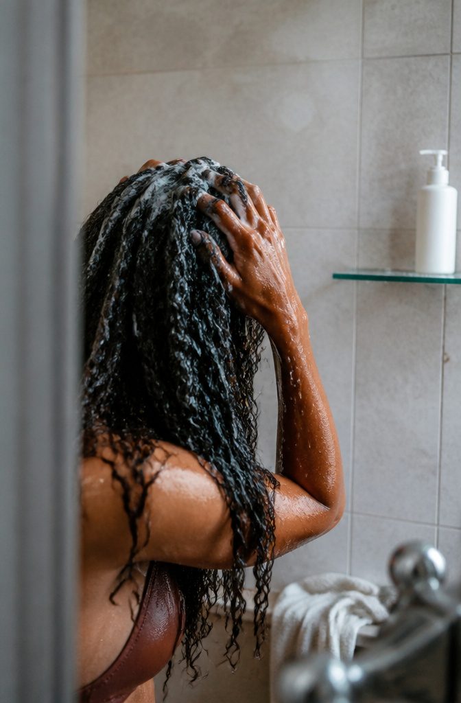 Thick curly hair shampooed at the roots with defined damp lengths