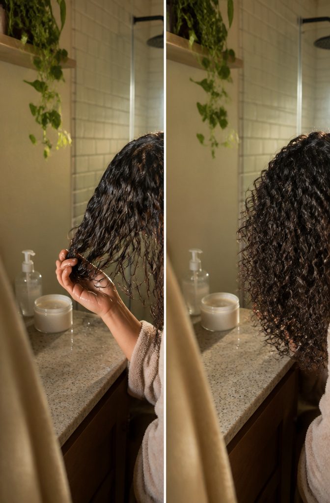 Hands scrunching styling product into damp curly hair