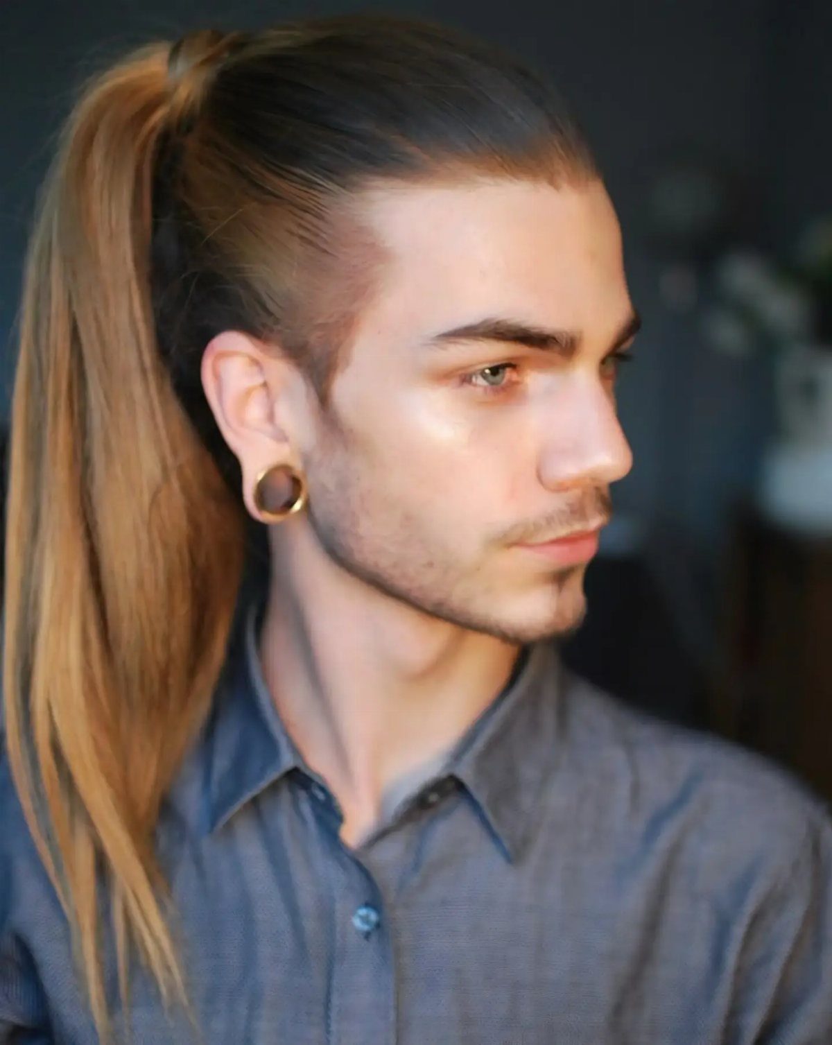 Man with long light brown hair tied back in a high ponytail.