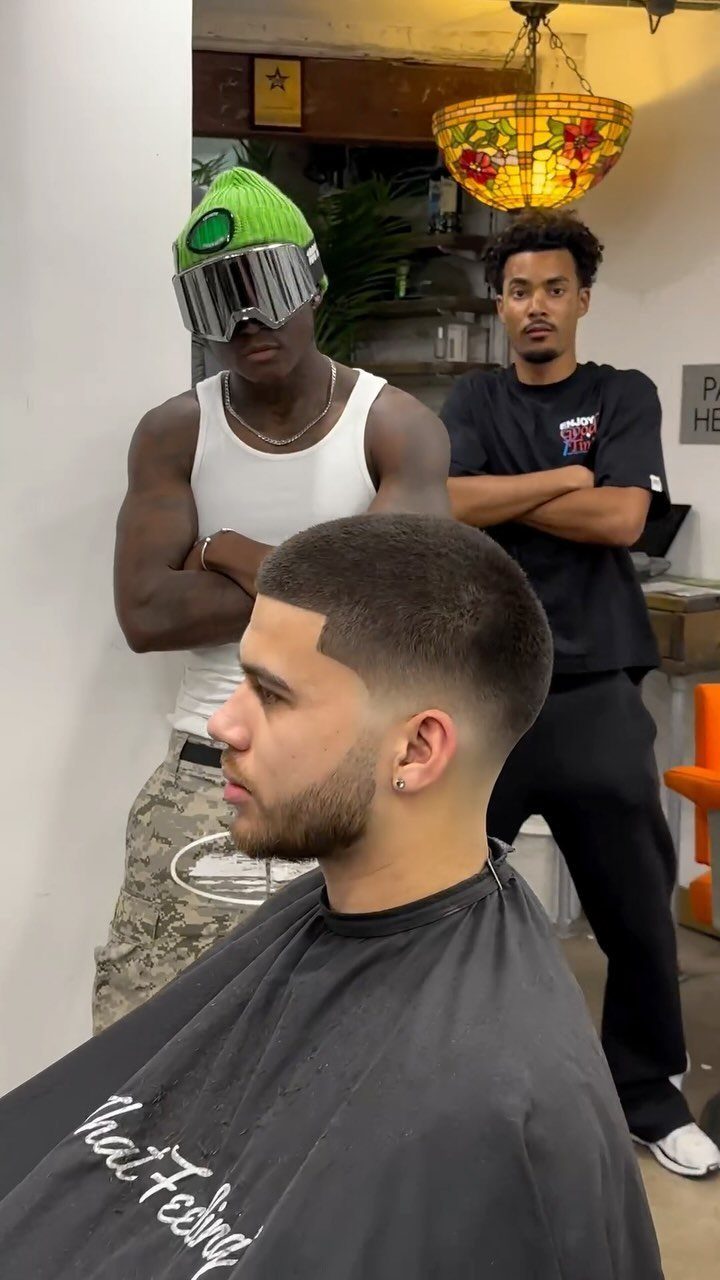 Man with a short buzz cut and low skin fade in a barbershop.