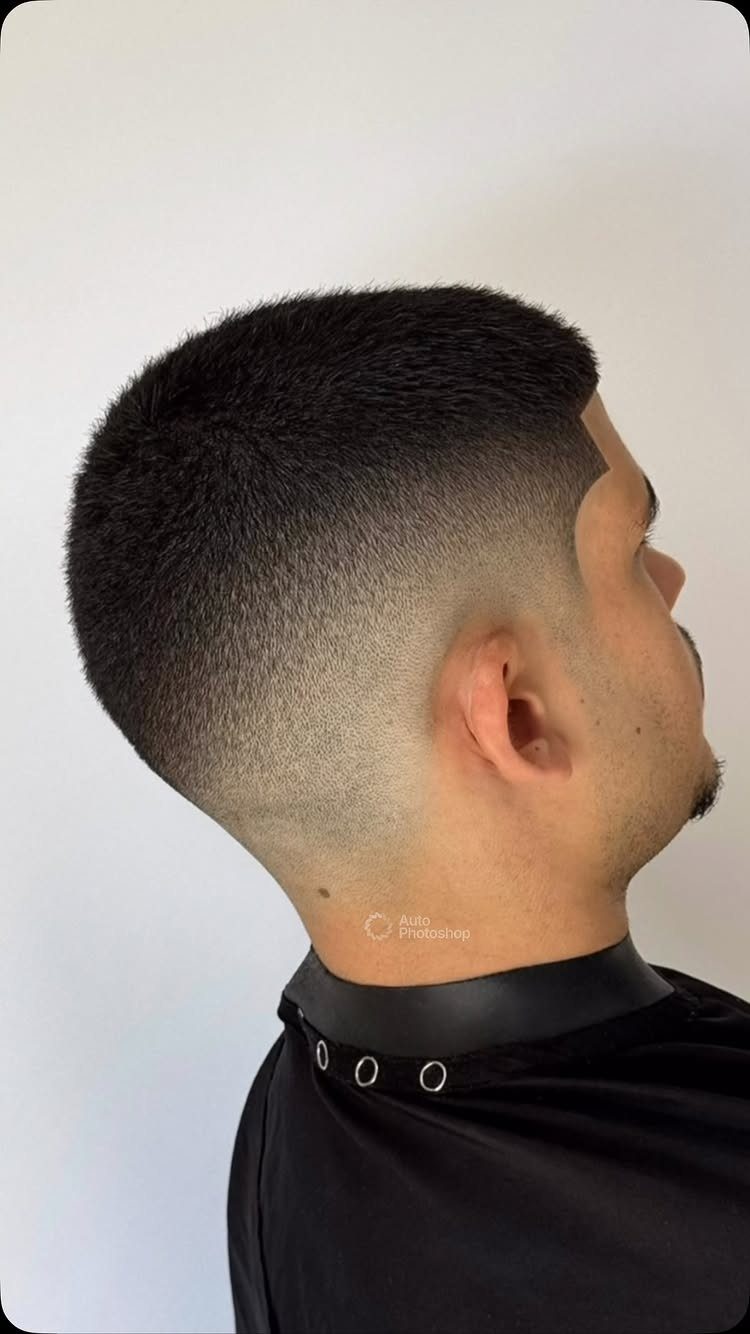 Man with a low skin fade haircut and short dark hair on top.