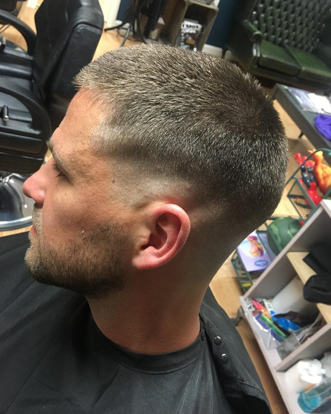 Man with a short crew cut and low skin fade in a barbershop.