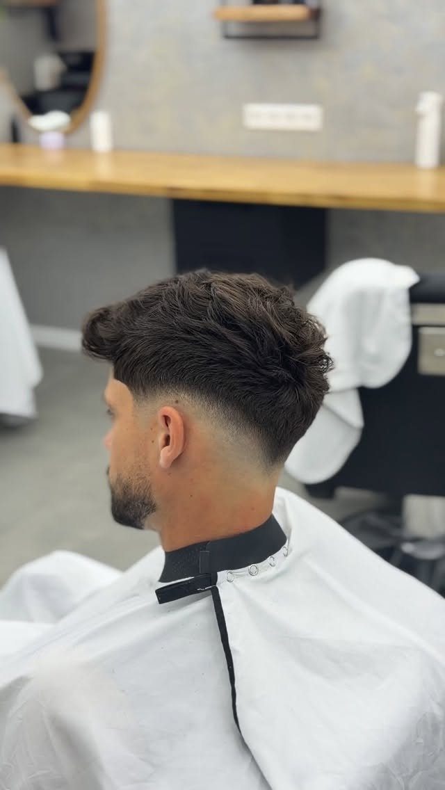 Man with a quiff hairstyle and low fade in a barbershop.