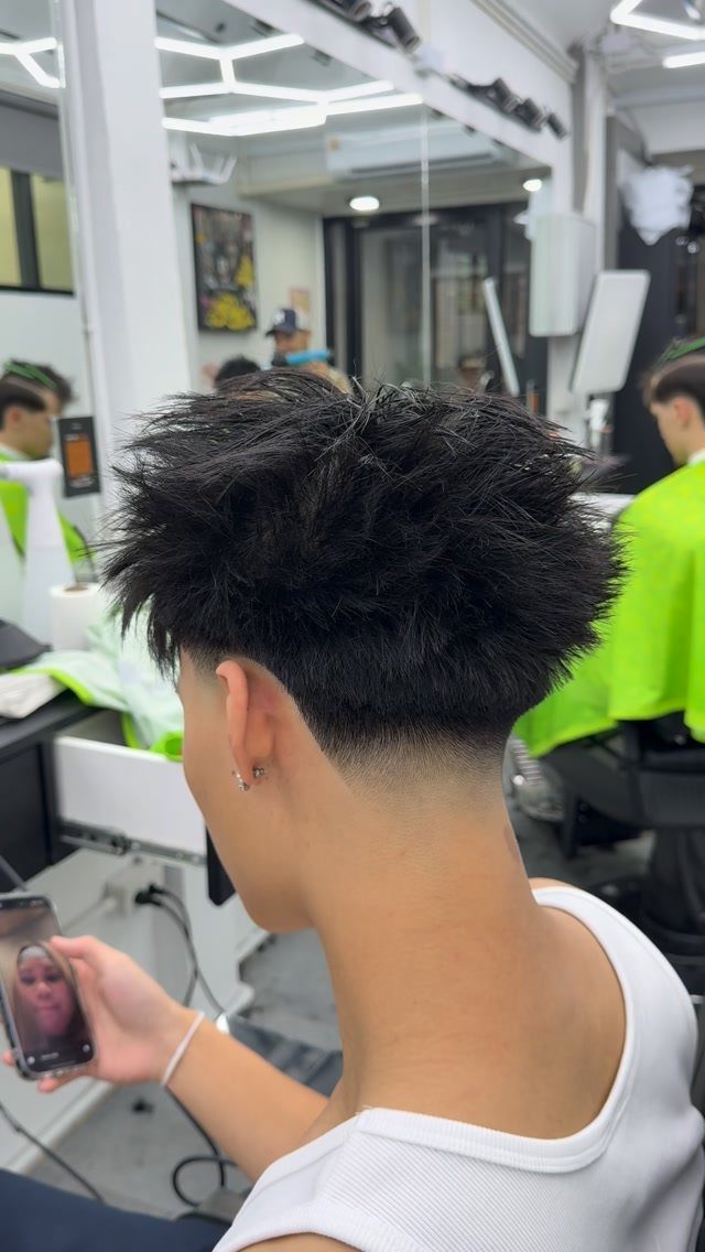 Man with voluminous textured top and a clean low taper fade haircut.