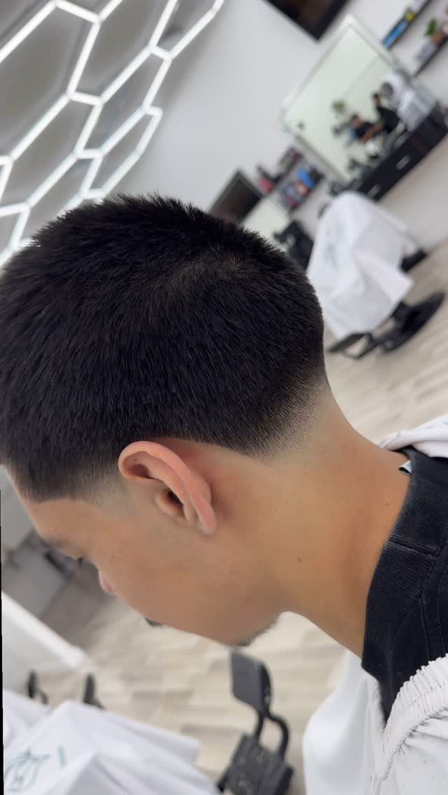 Man with a short buzz cut and a clean low taper fade haircut.