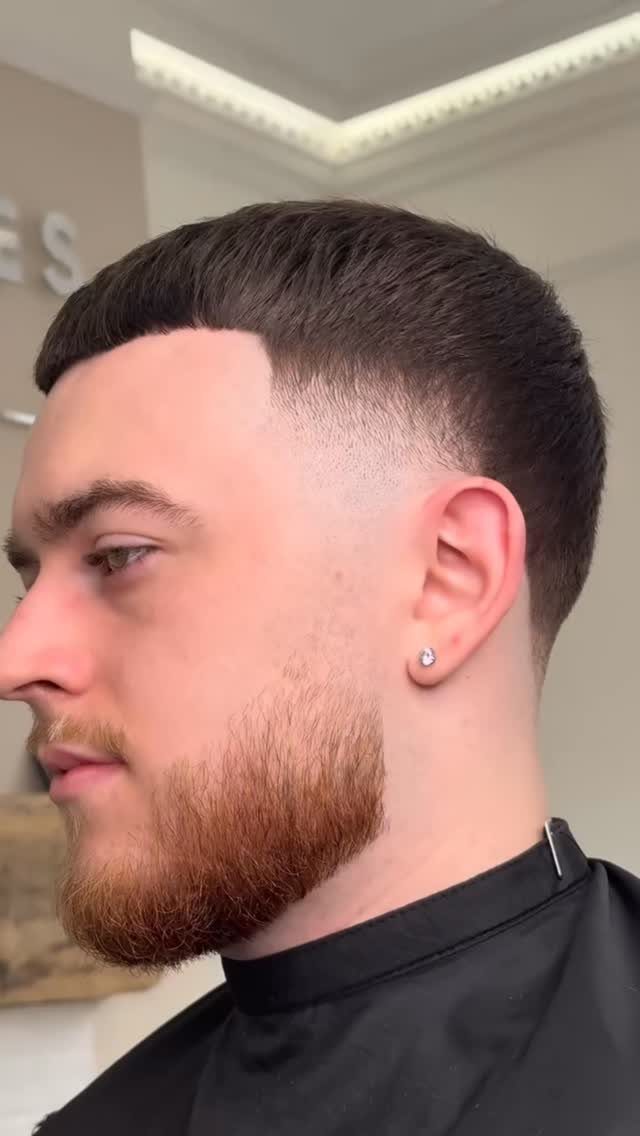 Man with a clean crop haircut, low taper fade, and groomed beard.