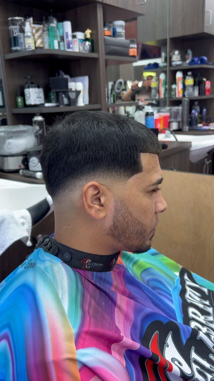 Man with a low skin fade haircut and groomed beard in a barbershop