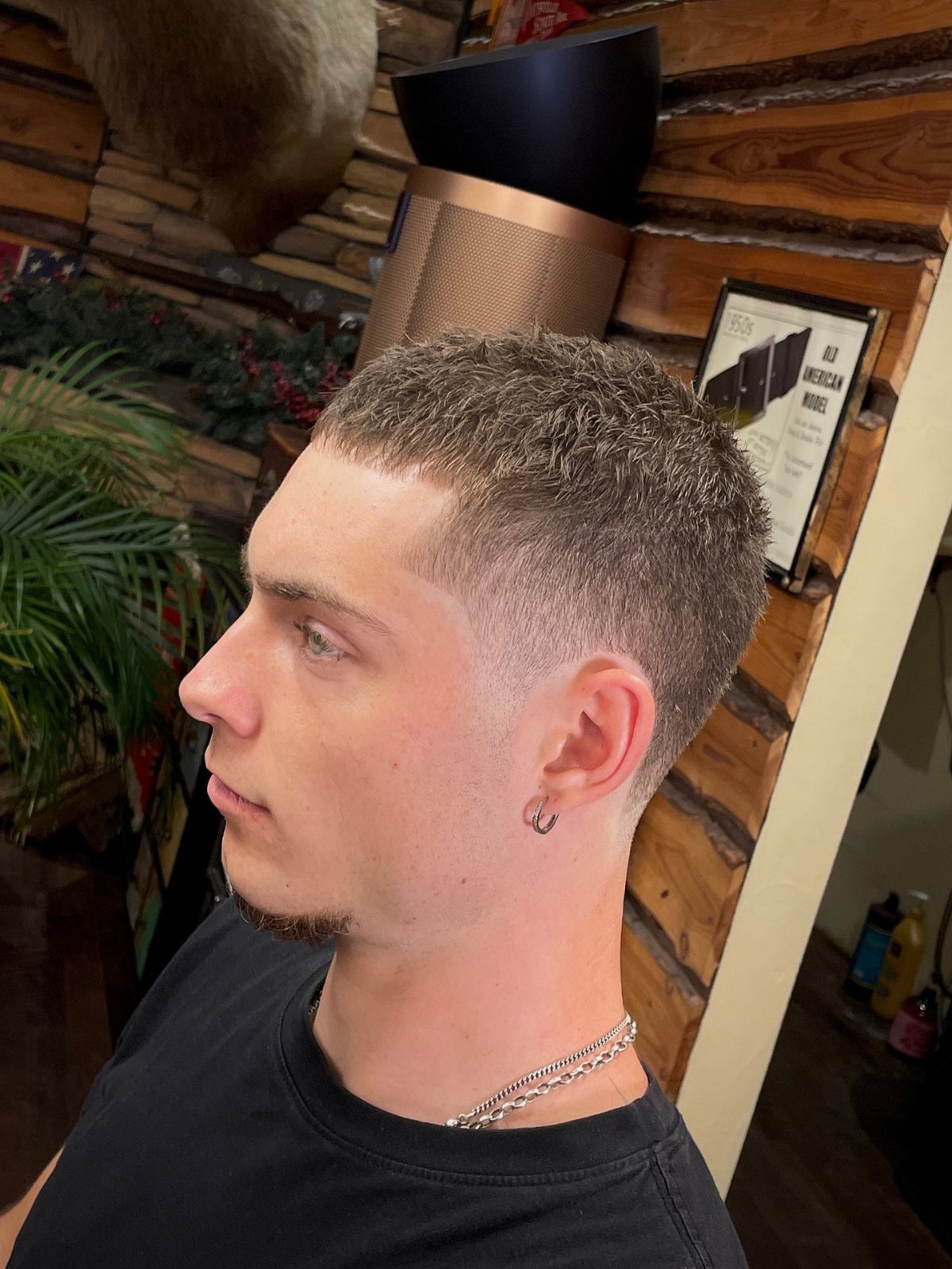 Man with a short textured crew cut and a clean low taper fade.