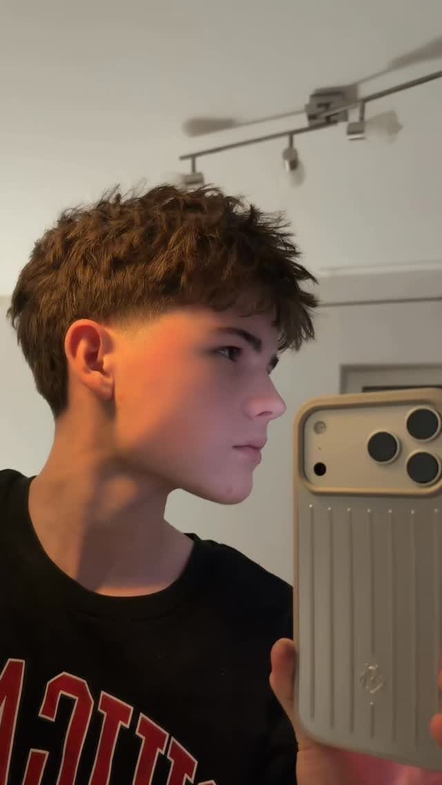 Young man with brown stylish spiky hair and a low taper fade.