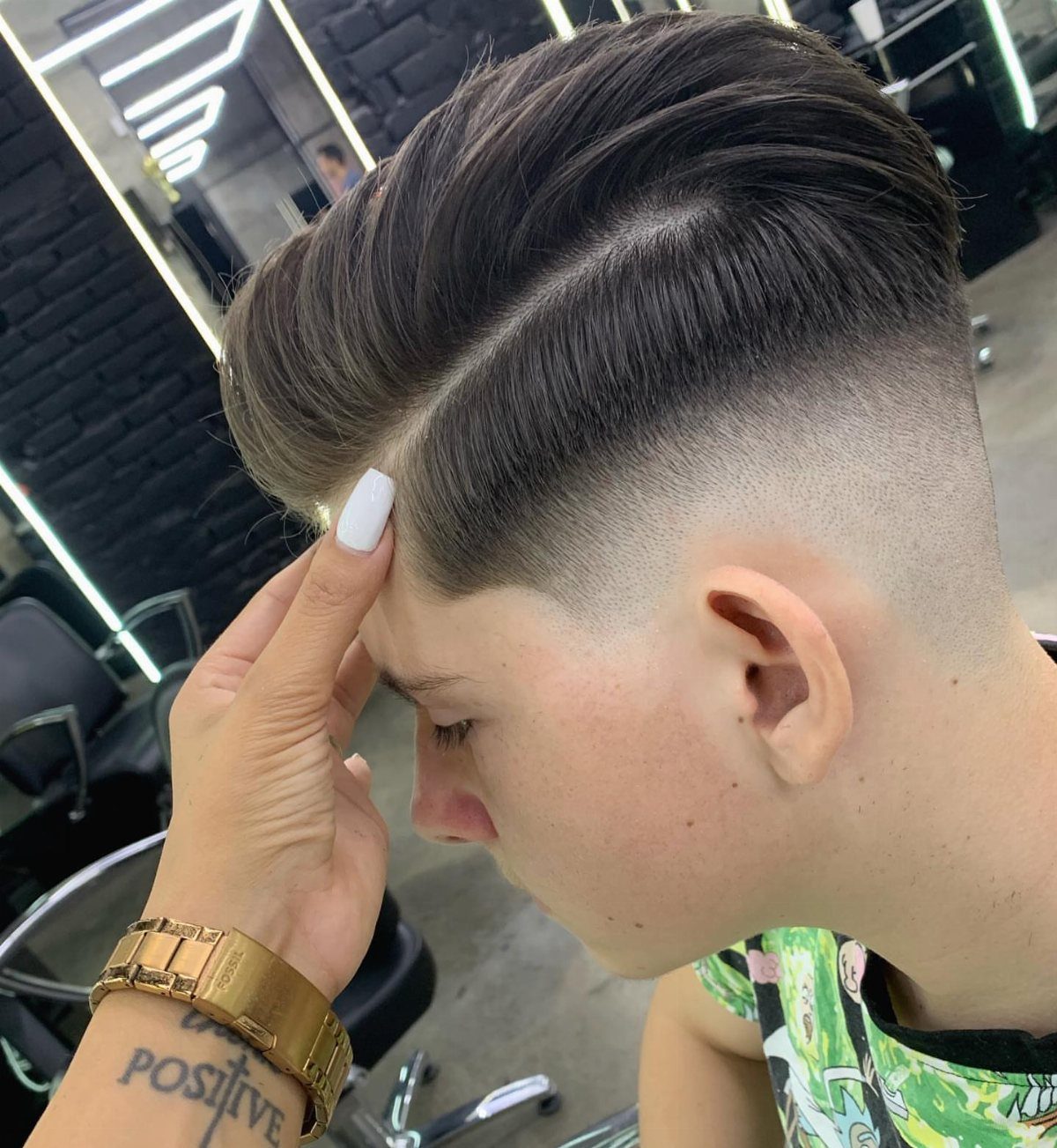 Man with a brown comb-over haircut and high skin fade in a barbershop.