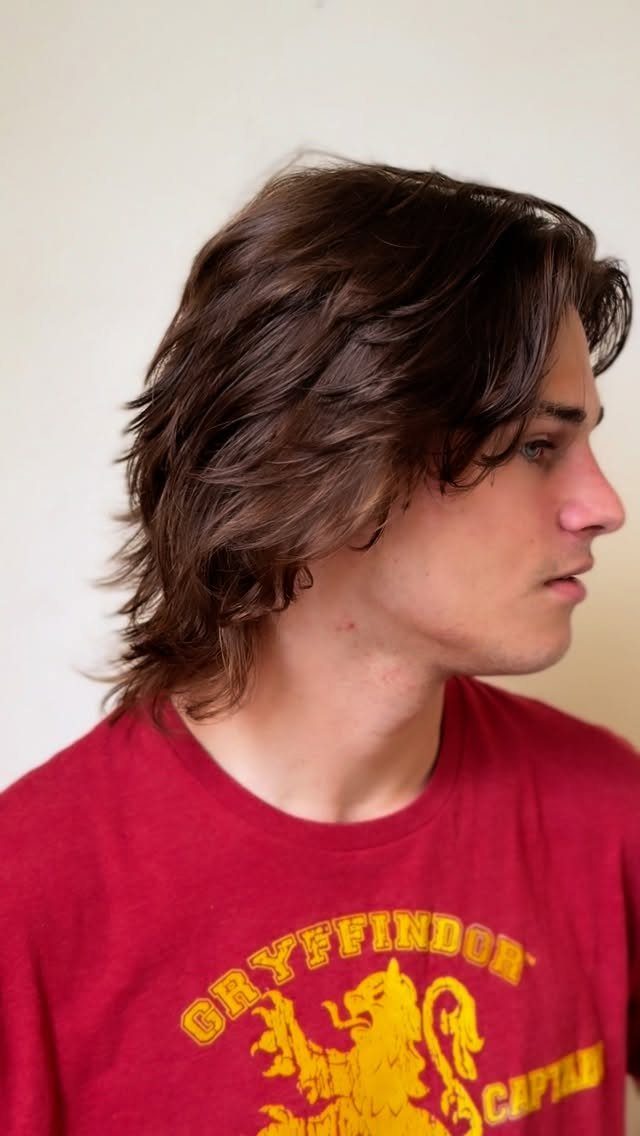 Young man with brown flowy mid-length hair wearing a red Gryffindor t-shirt.