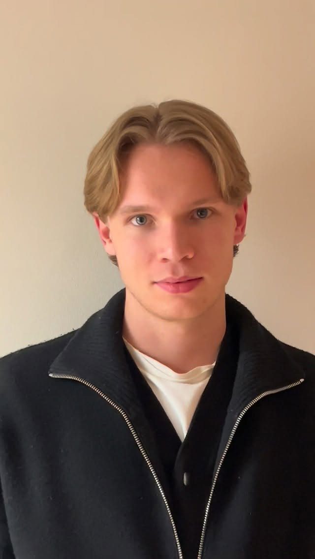 Young man with medium-length light brown hair and a middle part.