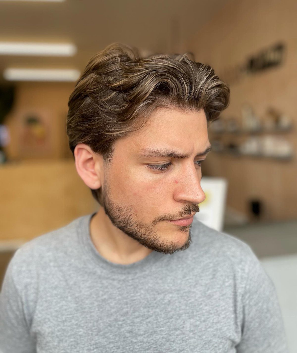 Man with wavy medium length brown hair and a groomed short beard.