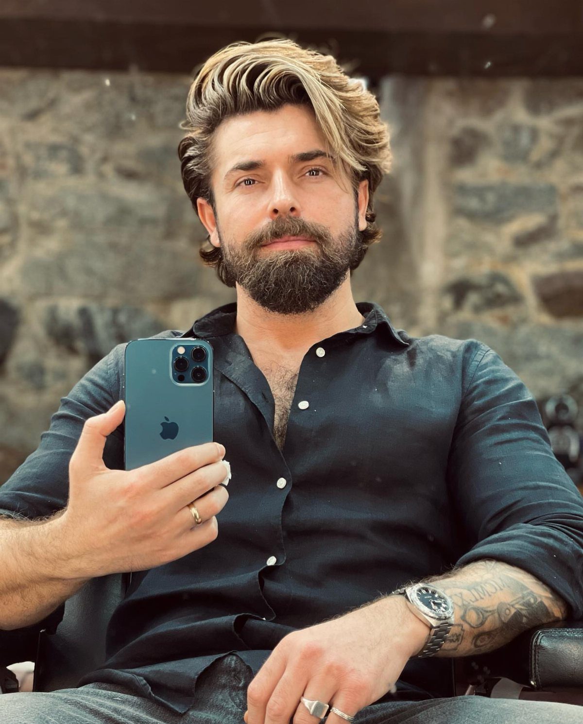 Man with swept back medium length blonde hair and a full beard.
