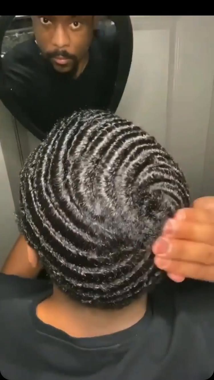 Back of a man's head featuring short hair styled in deep 360 waves.