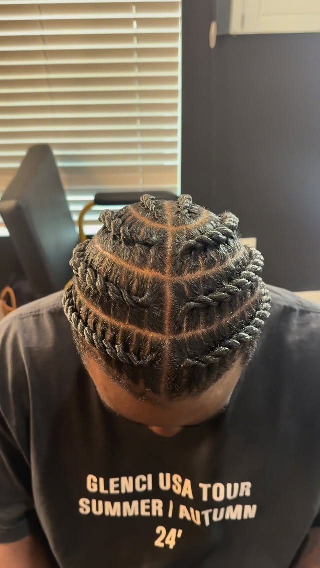 Man's head with black hair styled in precise flat twists against the scalp.