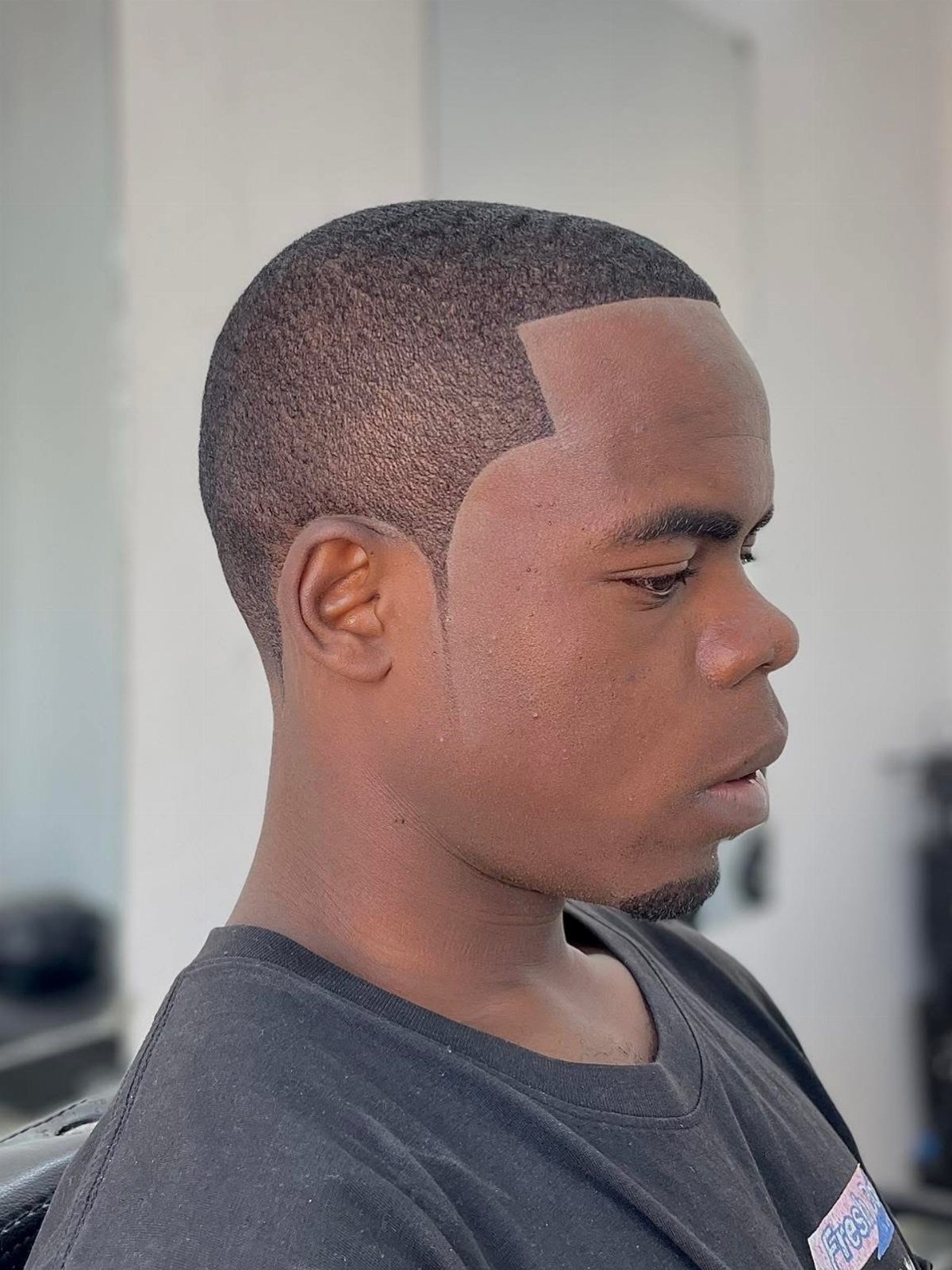 Black man with a short low cut hairstyle and a clean edge-up line.