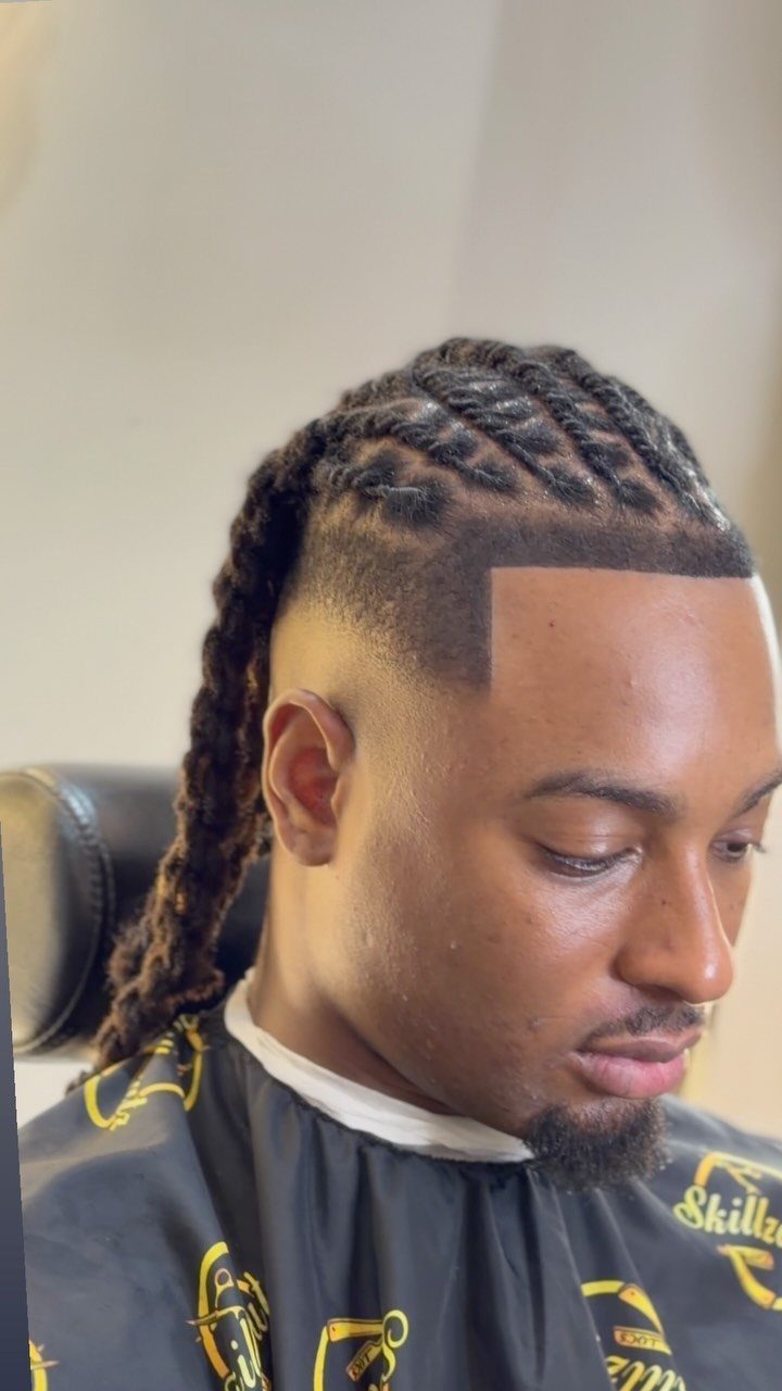 Man with long twists on top and a clean skin fade haircut.